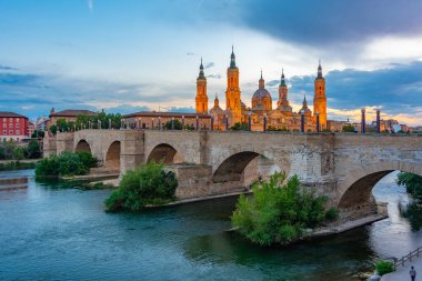 İspanya 'nın Zaragoza kentindeki Basilica de nuestra senora de pilar ve puente de piedra' nın günbatımı manzarası.