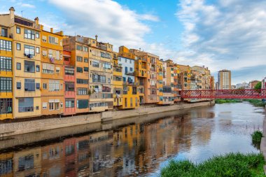İspanya 'nın Girona kentindeki nehir kenarındaki renkli evlerin günbatımı manzarası.