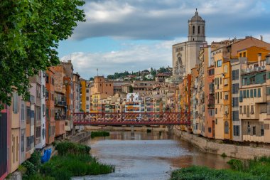 İspanya 'nın Girona kentindeki nehir kenarındaki renkli evlerin günbatımı manzarası.