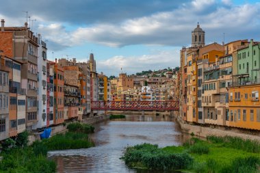 İspanya 'nın Girona kentindeki nehir kenarındaki renkli evlerin günbatımı manzarası.