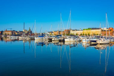 Helsinki, Finlandiya 'daki Kruununhaka marinasının üzerinde Uspenski Katedrali yükseliyor .