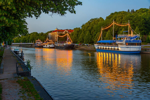 Sunset view of boats mooring alongside river Aura in Turku, Finland.