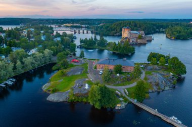 Savonlinna, Finlandiya 'daki Olavinlinna kalesi ve Riihisaari Müzesi' nin gün batımı manzarası.