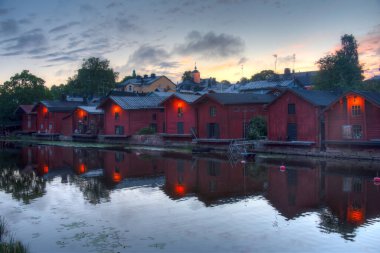 Finlandiya 'nın Porvoo kentindeki kırmızı ahşap kulübelerin gün doğumu manzarası.