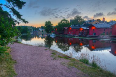 Finlandiya 'nın Porvoo kentindeki kırmızı ahşap kulübelerin gün doğumu manzarası.