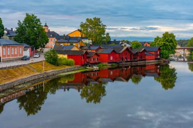 Finlandiya 'nın Porvoo kentindeki kırmızı ahşap kulübelerin gün doğumu manzarası.