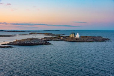 Finlandiya 'daki Aland adalarında Kobba Klintar pilot istasyonu üzerinde gün doğumu.