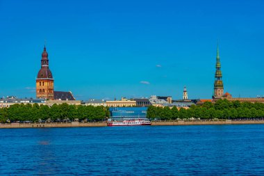 Letonya 'nın Daugava nehrinin diğer yakasındaki Riga Katedrali ve Aziz Peter Kilisesi manzarası...