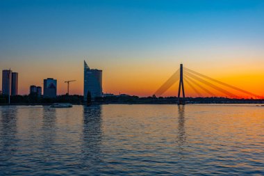 Letonya 'nın Riga kentindeki Daugava nehri üzerindeki Vansu yatık köprüsünün gün batımı manzarası..