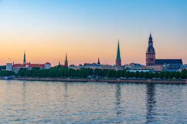 Riga kalesi, katedral ve Letonya 'daki Aziz James kilisesi de dahil olmak üzere günbatımı riga manzarası.. .