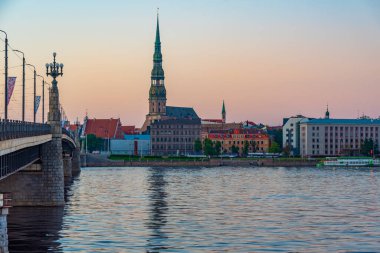 Eski kasaba Riga 'da gün batımı Aziz Peter Kilisesi de dahil Dagava nehri üzerinde, Letonya..