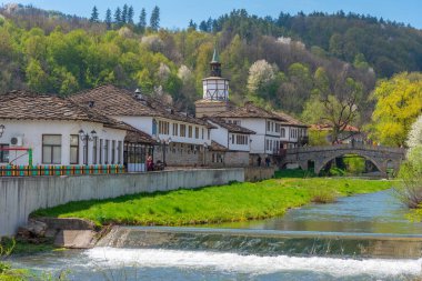 historical clock tower in the center of Tryavna behind a river, Bulgaria. clipart