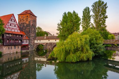 Weinstadel binasının, su kulesinin, Henkerbrucke köprüsünün ve Almanya 'nın Nurnberg kentindeki Henkerturm kulesinin günbatımı manzarası..