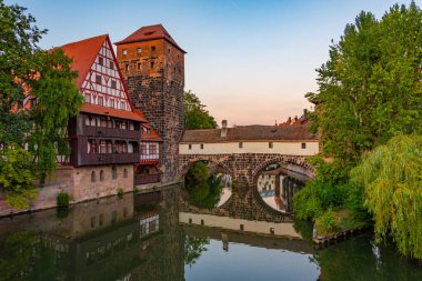 Weinstadel binasının, su kulesinin, Henkerbrucke köprüsünün ve Almanya 'nın Nurnberg kentindeki Henkerturm kulesinin günbatımı manzarası..