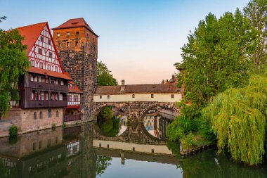 Weinstadel binasının, su kulesinin, Henkerbrucke köprüsünün ve Almanya 'nın Nurnberg kentindeki Henkerturm kulesinin günbatımı manzarası..