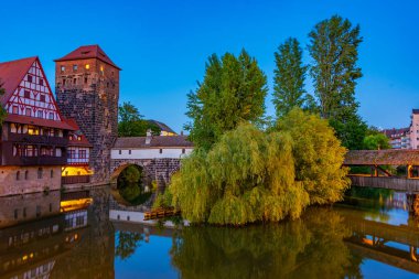 Weinstadel binasının, su kulesinin, Henkerbrucke köprüsünün ve Almanya 'nın Nurnberg kentindeki Henkerturm kulesinin günbatımı manzarası..
