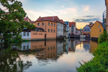 Alman şehri Bamberg 'in Regnitz nehrine yansıyan günbatımı manzarası.