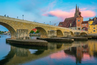 Almanya 'nın Regensburg kentindeki Tuna Nehri üzerindeki Eski Taş Köprü' nün gün batımı manzarası.