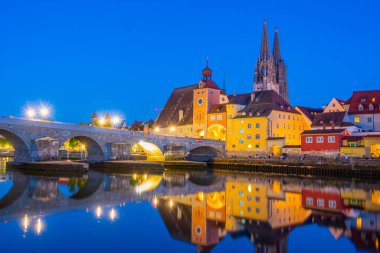 Almanya 'nın Regensburg kentindeki Tuna Nehri üzerindeki Eski Taş Köprü' nün gün batımı manzarası.