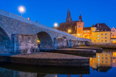 Almanya 'nın Regensburg kentindeki Tuna Nehri üzerindeki Eski Taş Köprü' nün gün batımı manzarası.