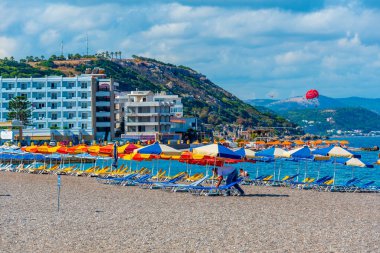 Yunanistan 'ın Rodos kentinde bir plajda güneşlik ve şemsiyeler.