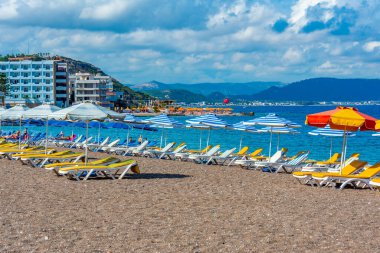 Yunanistan 'ın Rodos kentinde bir plajda güneşlik ve şemsiyeler.