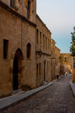 Yunanistan 'ın Rodos kentinde tarihi bir caddenin gün batımı manzarası.