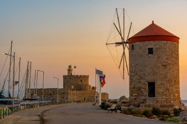 Yunanistan 'ın Rodos limanındaki antik yel değirmenlerinin gün doğumu manzarası.