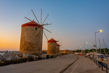Yunanistan 'ın Rodos limanındaki antik yel değirmenlerinin gün doğumu manzarası.