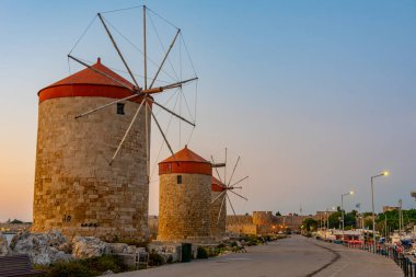 Yunanistan 'ın Rodos limanındaki antik yel değirmenlerinin gün doğumu manzarası.