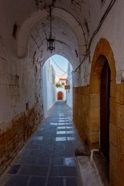 Yunan kenti Lindos 'un Rodos adasındaki beyaz sokaklarının gün batımı manzarası.