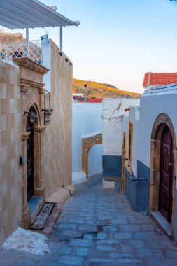 Yunan kenti Lindos 'un Rodos adasındaki beyaz sokaklarının gün batımı manzarası.