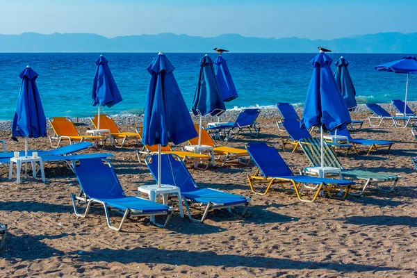 希腊罗得镇海滩上的日光浴床和雨伞 — 图库照片