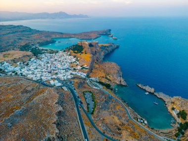 Rodos 'taki Yunan kenti Lindos' taki Saint Paul plajı ve Akropolis 'in günbatımı manzarası.