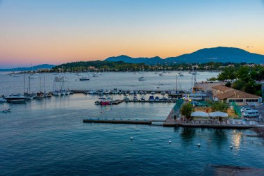 Korfu Yunanistan limanında demirleyen yatların günbatımı manzarası.