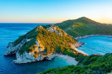 Yunan adası Korfu 'daki Porto Timoni plajının gün batımı manzarası.