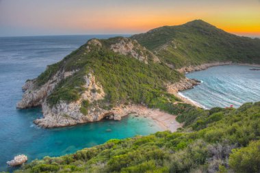 Yunan adası Korfu 'daki Porto Timoni plajının gün batımı manzarası.