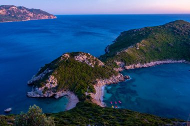 Yunan adası Korfu 'daki Porto Timoni plajının gün batımı manzarası.