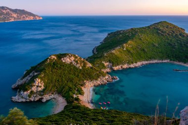 Yunan adası Korfu 'daki Porto Timoni plajının gün batımı manzarası.