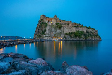 İtalyan adası Ischia açıklarındaki Castello Aragonese 'nin günbatımı manzarası.