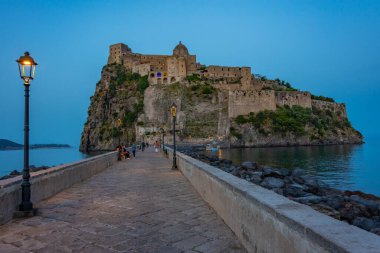 İtalyan adası Ischia açıklarındaki Castello Aragonese 'nin günbatımı manzarası.