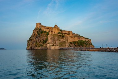 İtalyan adası Ischia açıklarındaki Castello Aragonese 'nin günbatımı manzarası.