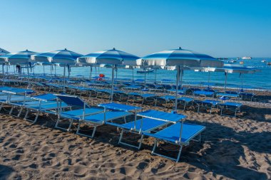 İtalya 'daki Positano plajında mavi ve beyaz şemsiyeler.