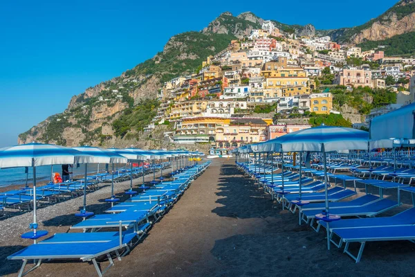 İtalya 'daki Positano plajında mavi ve beyaz şemsiyeler.