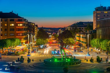 İsveç 'in Goteborg şehrinde Poseidon heykeli bulunan Kungsportsavenyen Bulvarı' nın gün batımı manzarası.