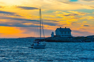 Günbatımında Marstrand 'a dönen yat, İsveç.