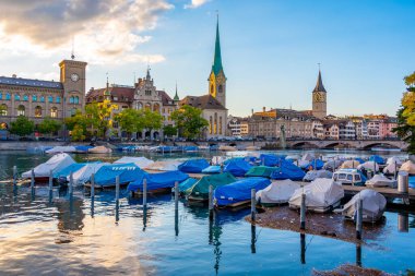 İsviçre 'de güneşli bir günde ünlü Fraumuenster Kilisesi ve Limmat nehri ile tarihi Zuerich şehir merkezinin panoramik manzarası.