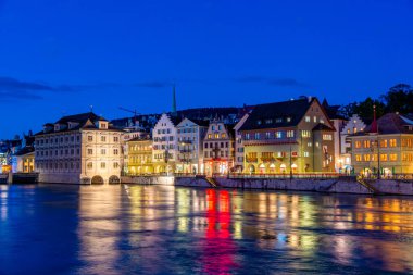 İsviçre 'nin Zuerich şehrinde tarihi belediye binası olan Limmat nehrinin rıhtımının gün batımı manzarası.