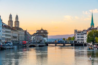 Ünlü Fraumuenster ve Grossmuenster Kiliseleri ve İsviçre Limmat nehri ile Zuerich 'in tarihi şehir merkezinin gün doğumu manzarası.