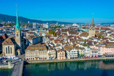 İsviçre 'de güneşli bir günde ünlü Fraumuenster Kilisesi ve Limmat nehri ile tarihi Zuerich şehir merkezinin panoramik manzarası.